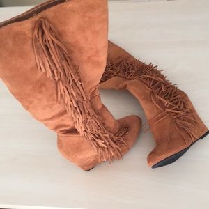 Knee high boot with fringe.